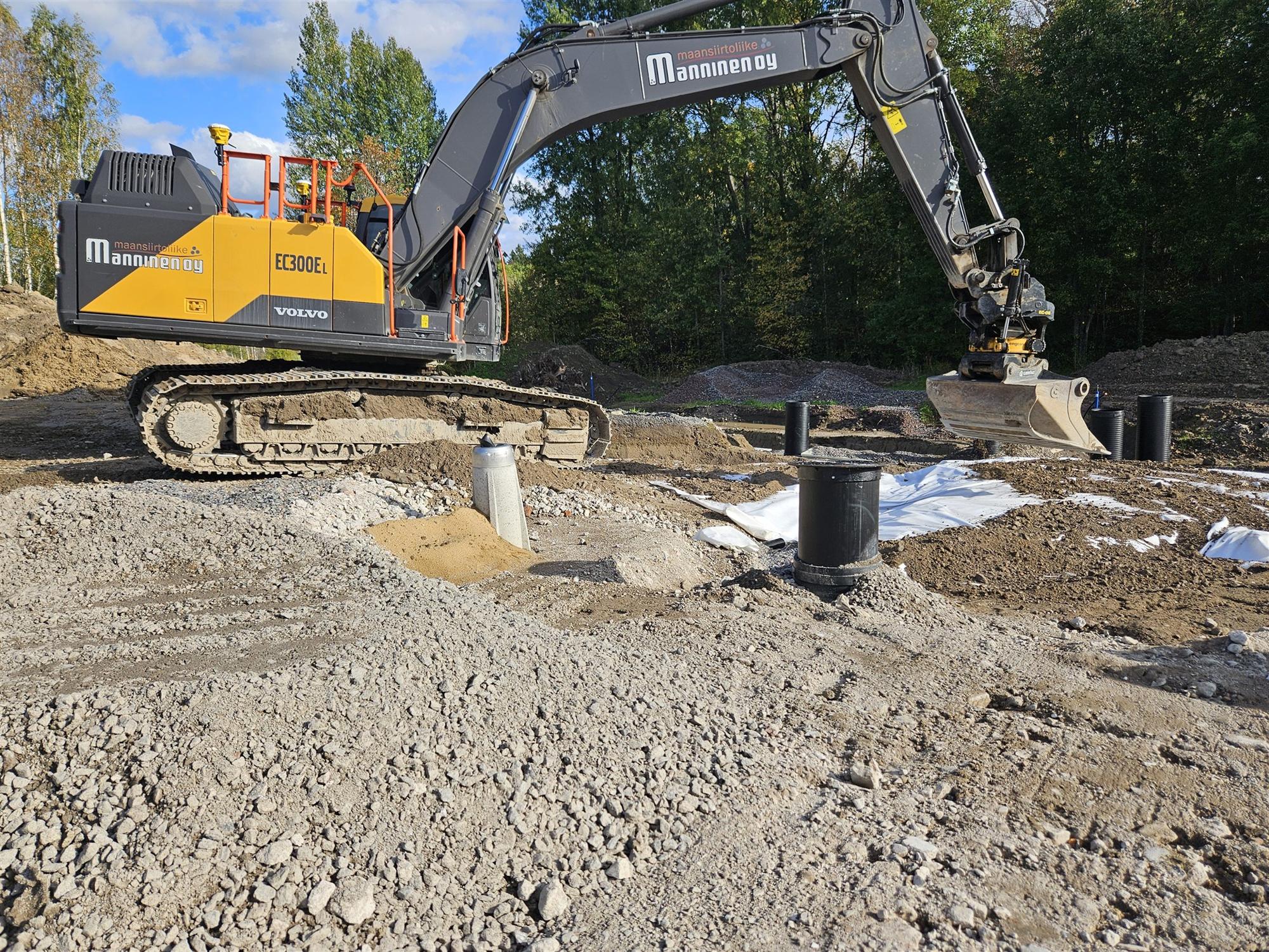 Kaivinkone asentaa tarkastuskaivoa